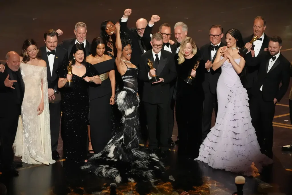 Jose Antonio Garcia (links), Florencia Martin, Leonardo DiCaprio, Cassandra Kulukundis, Regina Hall, Shayna McHale, Teyana Taylor, Michael Bauman, Paul Thomas Anderson, Anthony Carlino, Will Weike, Sara Murphy, Chase Infiniti, Christopher Scarabosio en Andy Jurgensen ontvingen de Oscar voor beste film met “One Battle After Another” tijdens de uitreiking van de Oscars op zondag 15 maart 2026 in het Dolby Theatre in Los Angeles.