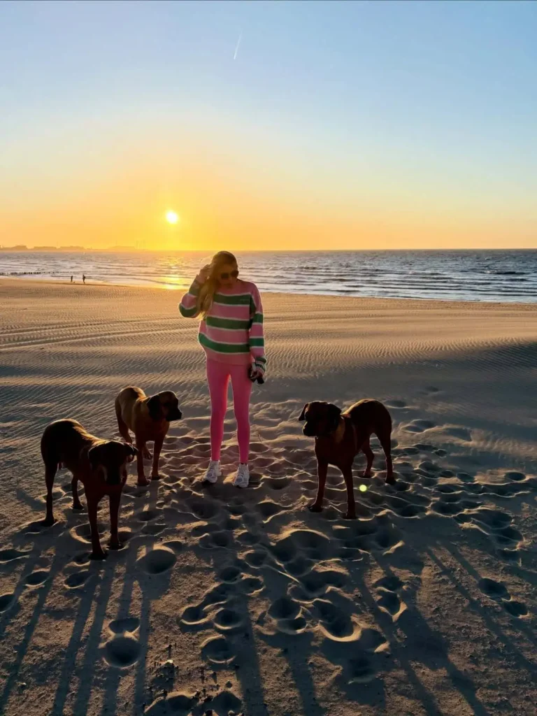 Charlotte Van Looy met haar honden bij zonsondergang op het strand van Knokke-Heist.